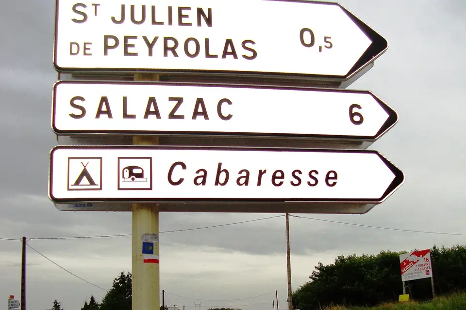 Panneaux routiers indicateurs en bordure de route dans le Gard, avec une coquille de balisage du chemin de Saint-Jacques
