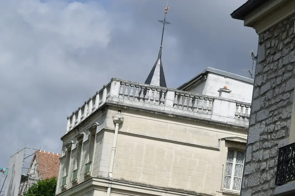 Rue de village bordée de maisons anciennes, dominée par la flèche d'un clocher d'église